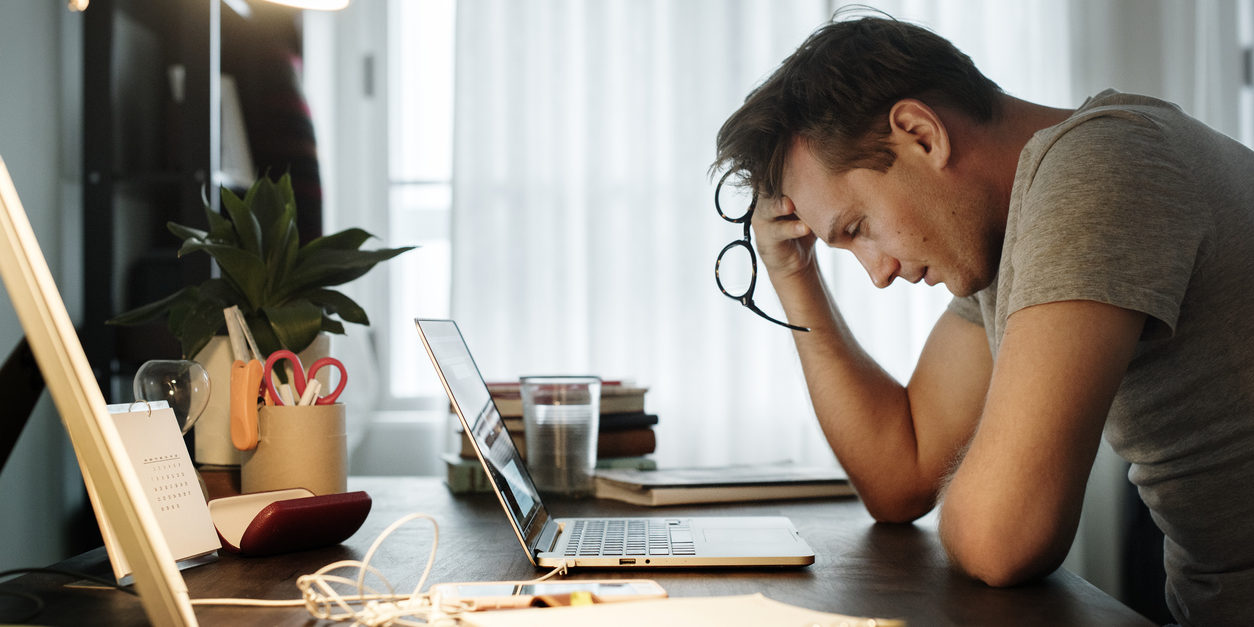 Man stressed while working on laptop
